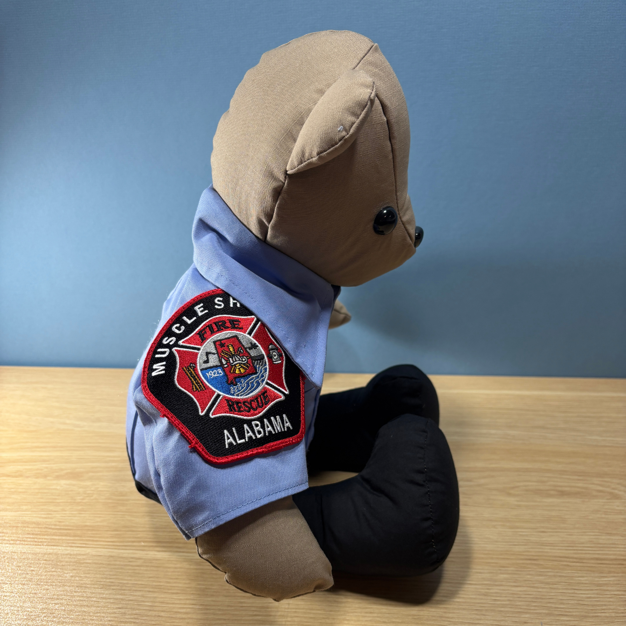 Side view of firefighter memory bear showing fire department patch on the sleeve of the bear