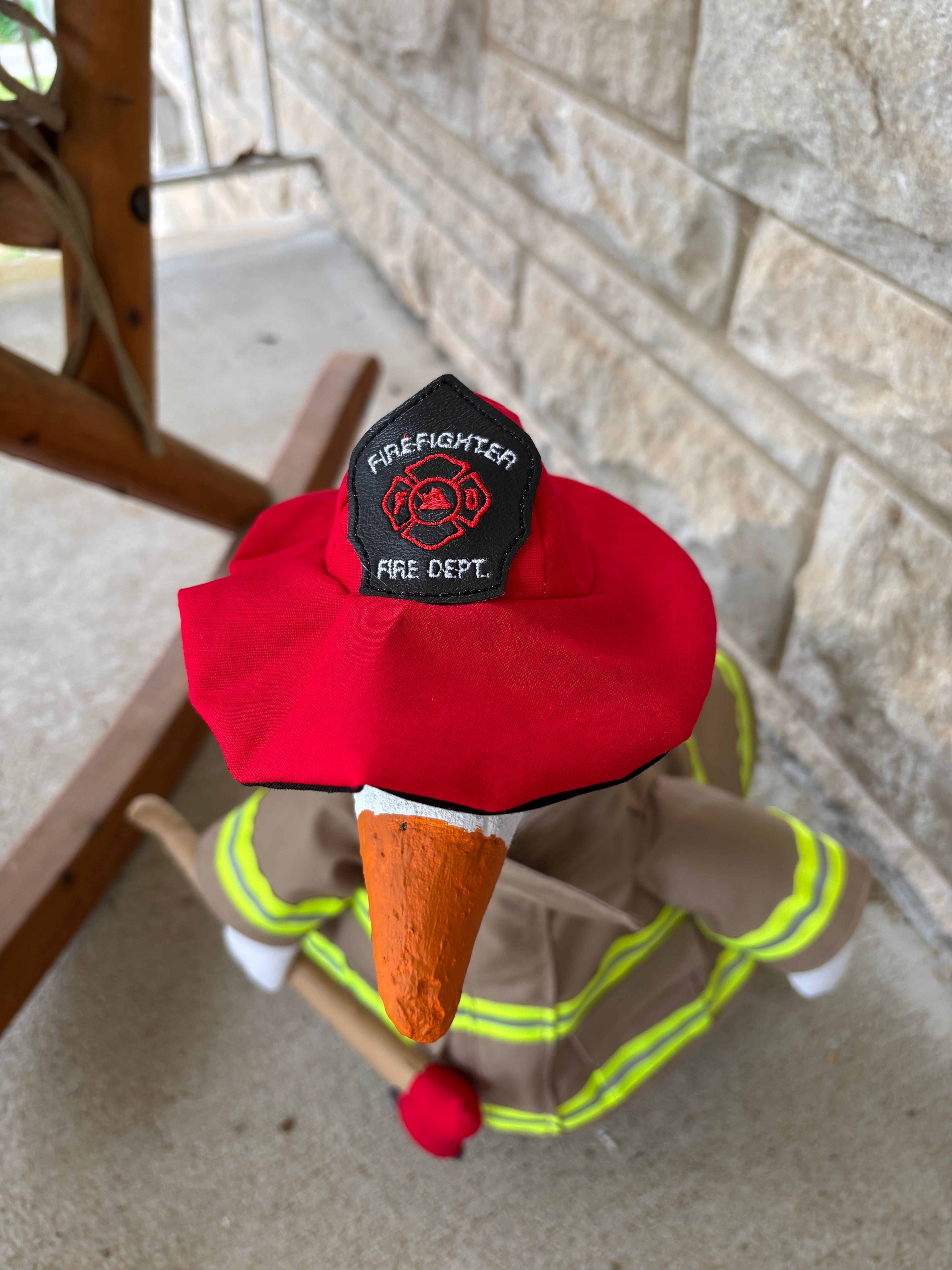 close up of firefighter hat for porch goose. uses elastic to stay on head