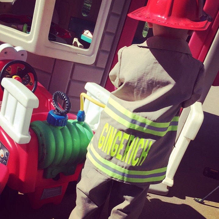 Toddler wearing Firefighter toddler jacket  back view with name